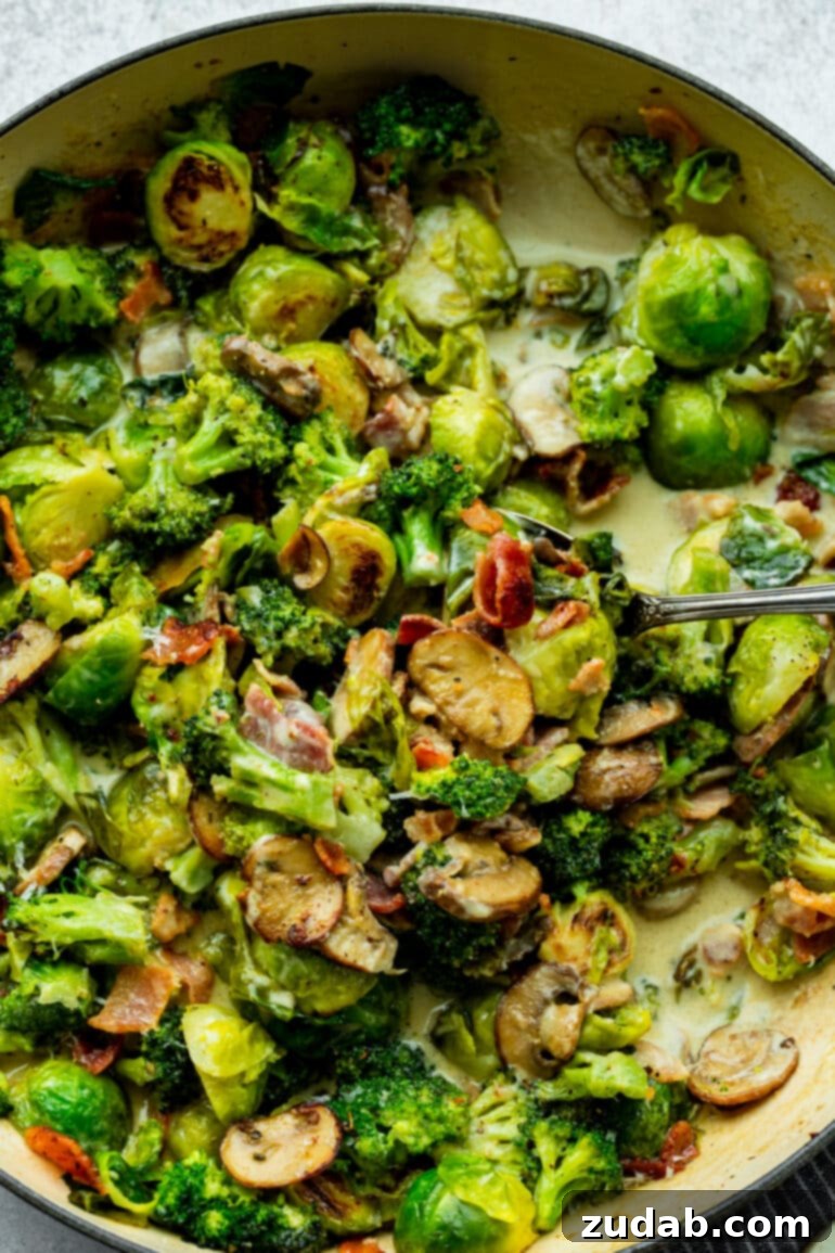 Luscious Garlic Parmesan Broccoli and Sprouts 7 A cast-iron skillet shows halved Brussels sprouts, sliced mushrooms, broccoli florets, and crispy bacon bits, all being sautéed in a creamy sauce, captured mid-preparation.