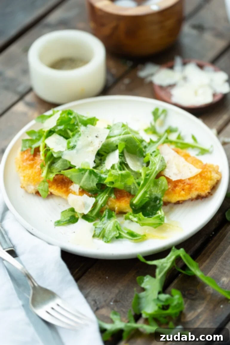 Weekly Meal Plan January 15-21 6 A golden breaded chicken breast, part of a Lightened Up Chicken Parmesan meal, served on a white dinner plate, topped with fresh salad greens, a delicate lemon vinaigrette, and shaved parmesan.
