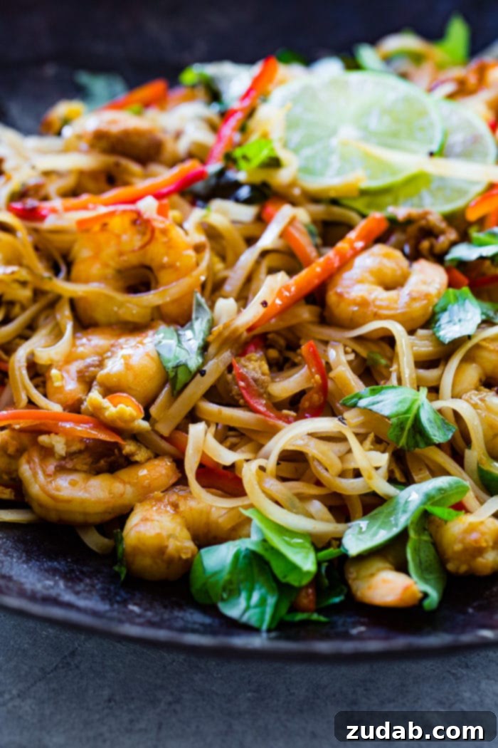 Weekly Meal Plan January 15-21 7 A beautifully arranged plate of cooked shrimp, delicate rice noodles, vibrant red bell peppers, and fresh basil leaves, garnished with bright slices of lime.