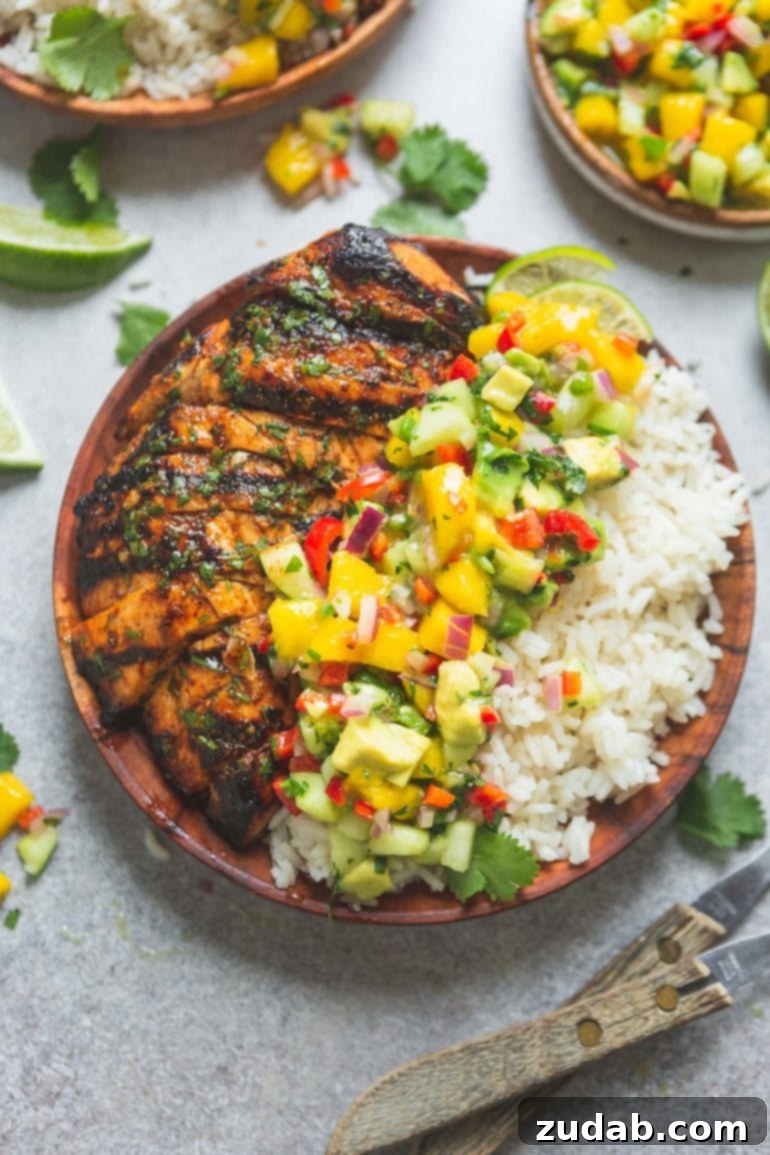 Weekly Menu Plan January 29 to February 4 4 A colorful dinner plate featuring perfectly grilled Mexican chicken, served alongside aromatic coconut rice, and a vibrant, chunky mango salsa with peppers and cilantro.