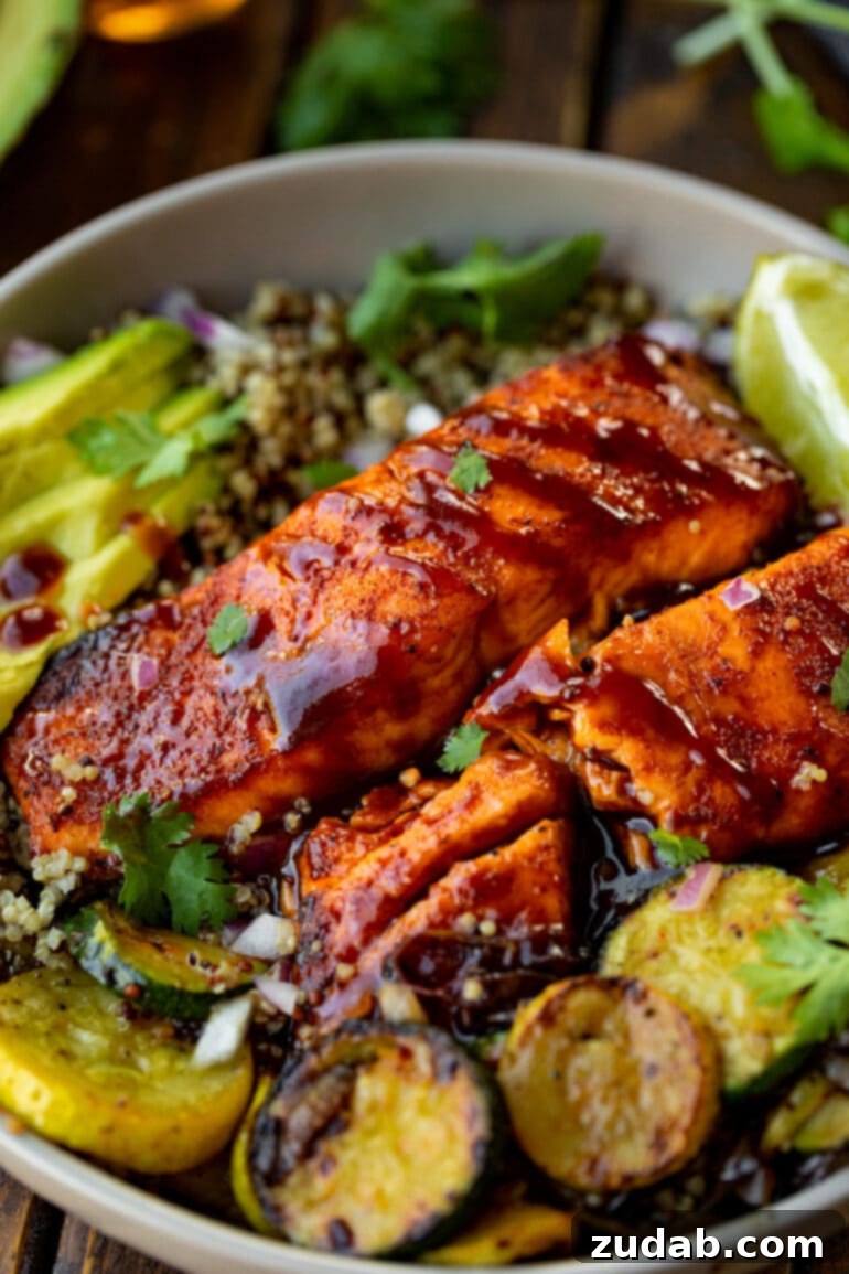 Weekly Menu Plan January 29 to February 4 6 Two perfectly cooked salmon fillets, glazed with a rich BBQ sauce, arranged on a plate with grilled zucchini slices, vibrant lime wedges, and creamy sliced avocado.