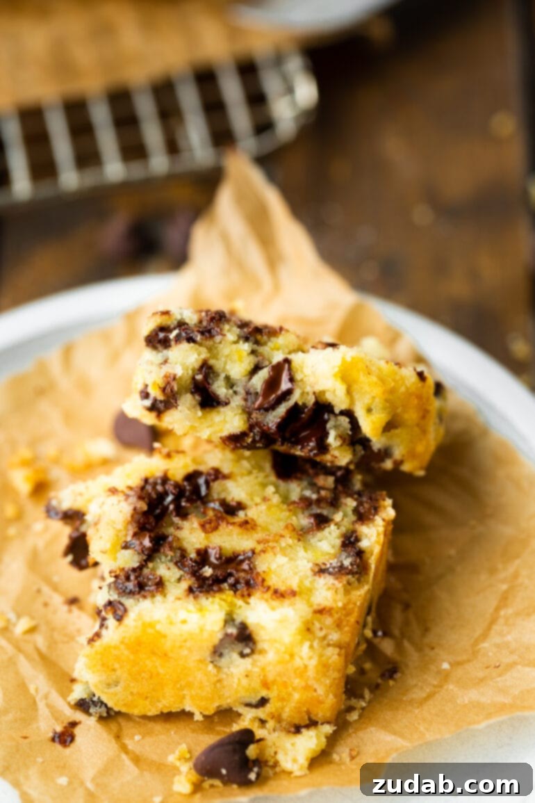 Bright Orange Chocolate Chip Scone Bread 6 Two pieces of orange chocolate chip scone bread, broken in half to reveal the tender, flaky cross-section loaded with melted chocolate chips, hinting at its irresistible taste.
