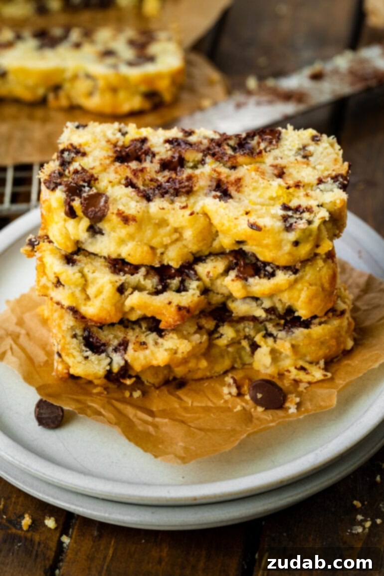 Bright Orange Chocolate Chip Scone Bread 7 A vibrant close-up photo of three slices of orange scone bread, generously studded with chocolate chips, ready to be enjoyed as a delightful sweet treat.