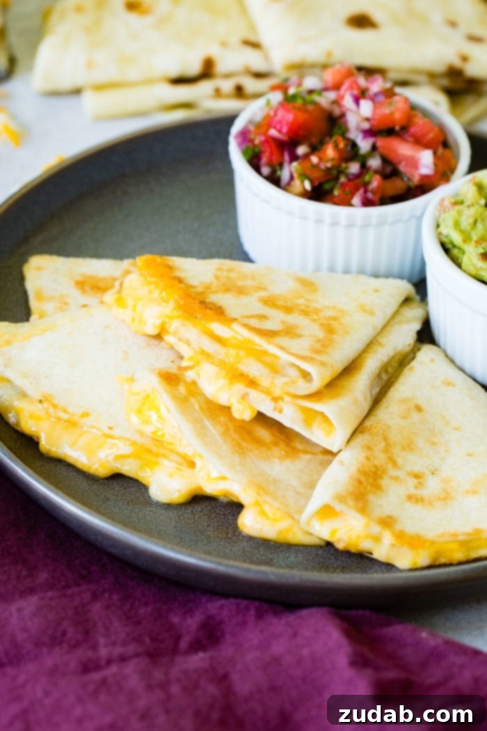 Weekly Meal Plan February 12 to 18 7 A stack of golden-brown, perfectly sliced quesadilla pieces, with melted, gooey cheese oozing out, artfully arranged on a rustic cutting board, accompanied by fresh pico de gallo and creamy guacamole, ready for a delicious and easy meal.