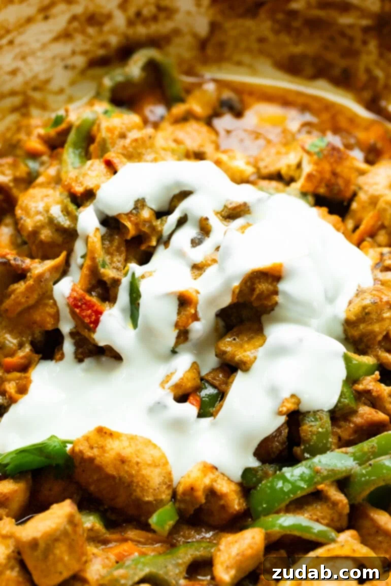 Easy One-Pan Creamy Chicken 3 A close-up shot of sautéed chicken chunks, vibrant bell peppers, tender onions, and earthy mushrooms, all richly coated in a luxurious, creamy sauce, ready to be served.