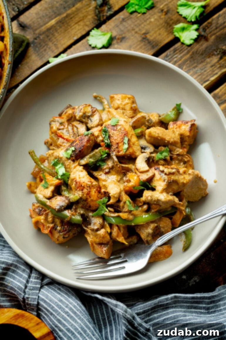 Easy One-Pan Creamy Chicken 4 A dinner plate showcasing a generous serving of Pollo a la Crema, garnished with fresh cilantro, ready to be enjoyed as a hearty meal.