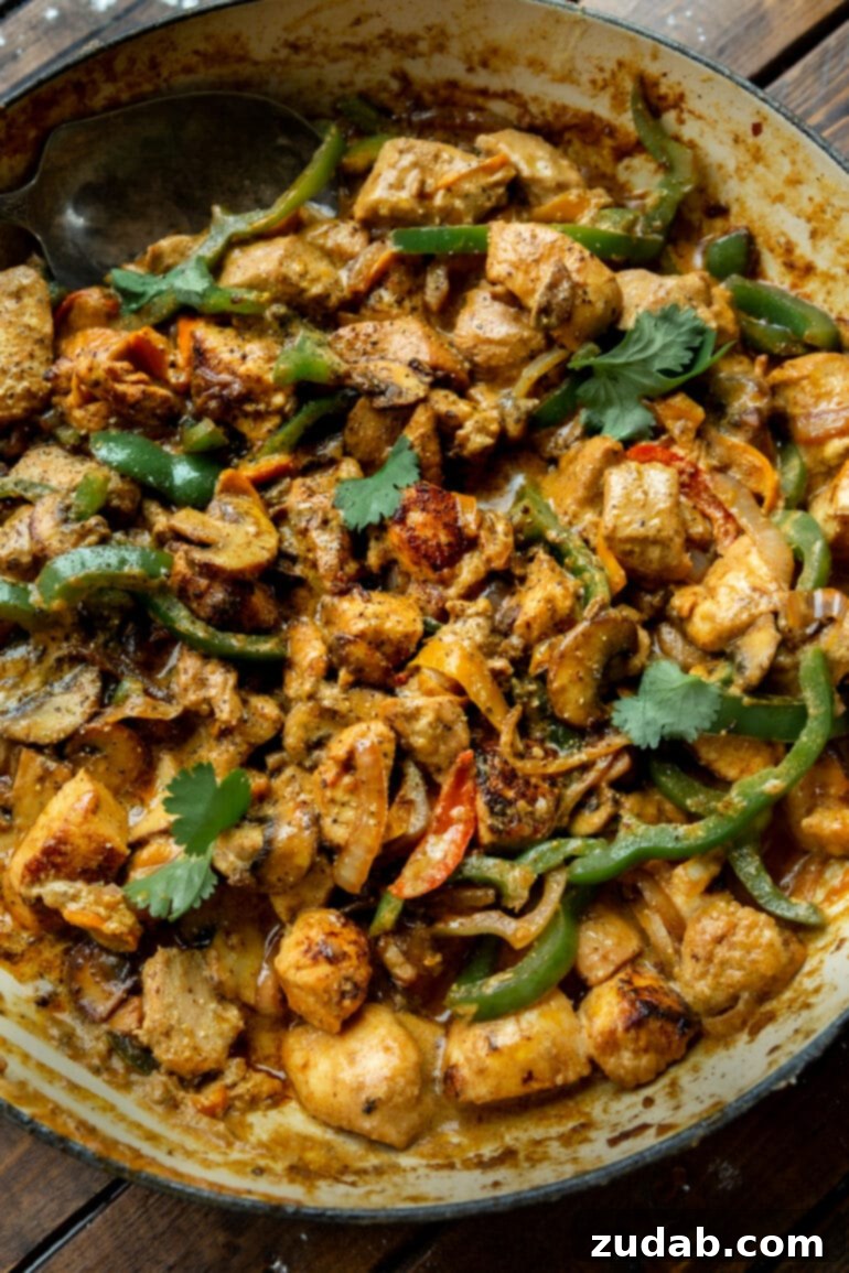 Easy One-Pan Creamy Chicken 7 A large skillet brimming with golden cooked chicken chunks, mixed with vibrant sautéed green bell peppers, sweet onions, and earthy mushrooms, all bathed in a luscious creamy sauce.