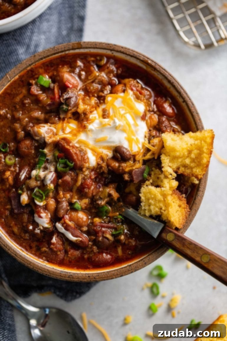 This Week's Meal Plan: February 19-25 8 A rich, steaming bowl of chili, generously topped with creamy sour cream and shredded cheese, with a golden piece of cornbread resting on the rim.