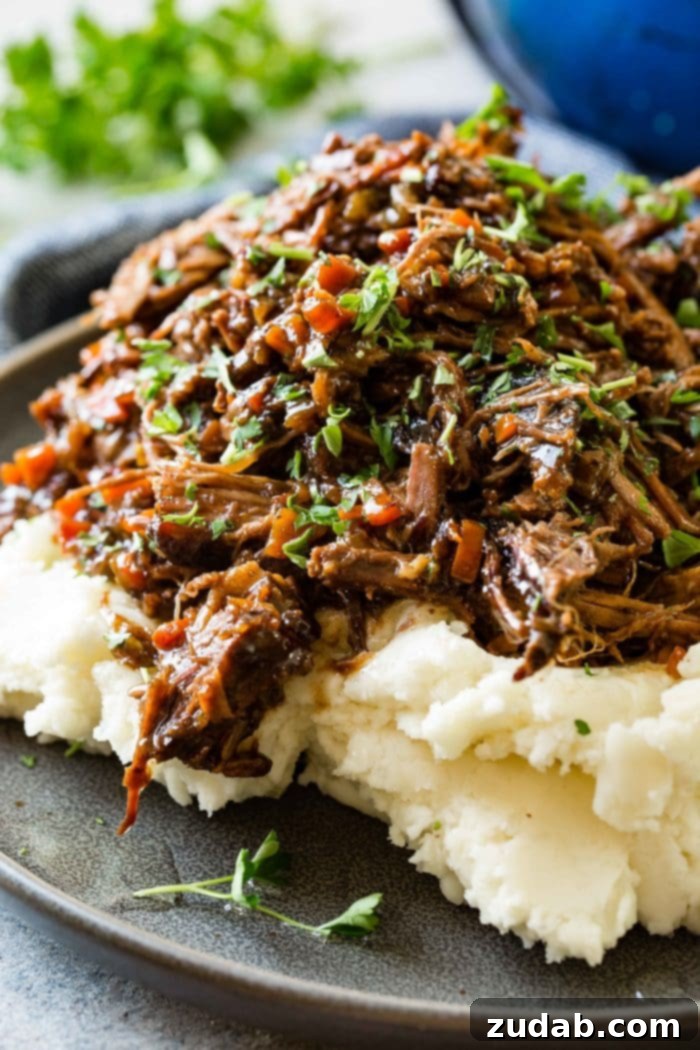 Weekly Meal Plan: March 4-10 9 A dark gray plate piled high with creamy mashed potatoes, generously topped with juicy, shredded Oven Braised Beef Roast and garnished with fresh chopped parsley.