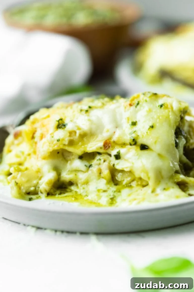 Effortless Creamy Pesto Chicken Lasagna 2 A beautifully plated slice of creamy chicken pesto lasagna, showcasing its vibrant green pesto and melted cheese layers, ready to be enjoyed.
