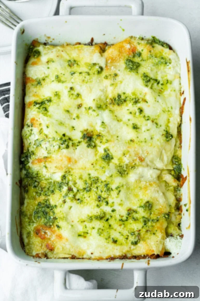 Effortless Creamy Pesto Chicken Lasagna 8 A golden-baked, creamy pesto chicken lasagna filling a 9x13 white casserole dish, fresh from the oven and ready to be served.