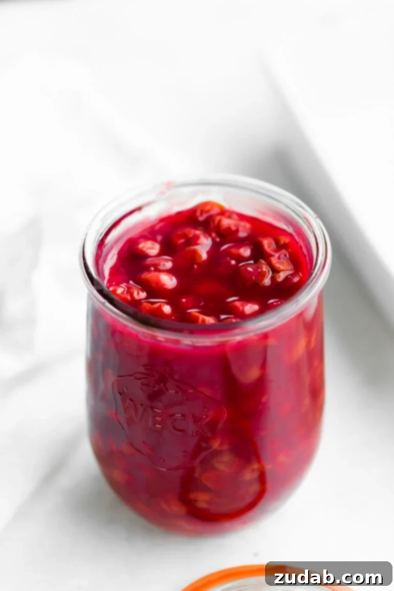 Luscious Homemade Cherry Pie Filling 2 a photo of a glass jar of bright red cherry pie filling