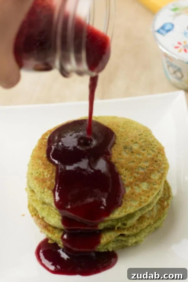 Perfectly cooked Green Monster Pancakes served warm with a drizzle of berry syrup, appealing to both kids and adults. Perfectly cooked Green Monster Pancakes served warm with a drizzle of berry syrup, appealing to both kids and adults.