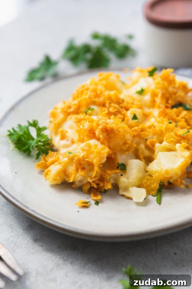 Your Ultimate Easter Sunday Feast 12 a photo of a serving of cheesy potato casserole on a white plate with golden crunchy topping.