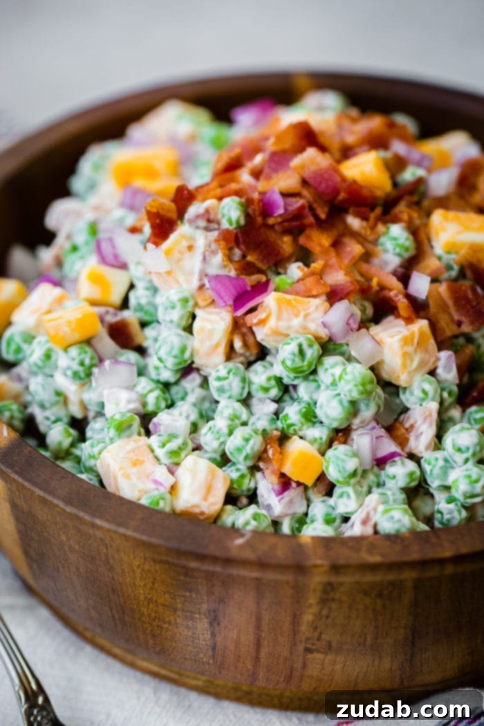 Your Ultimate Easter Sunday Feast 15 a wooden bowl full of creamy southern english pea salad with bacon, chunks of colby jack cheese