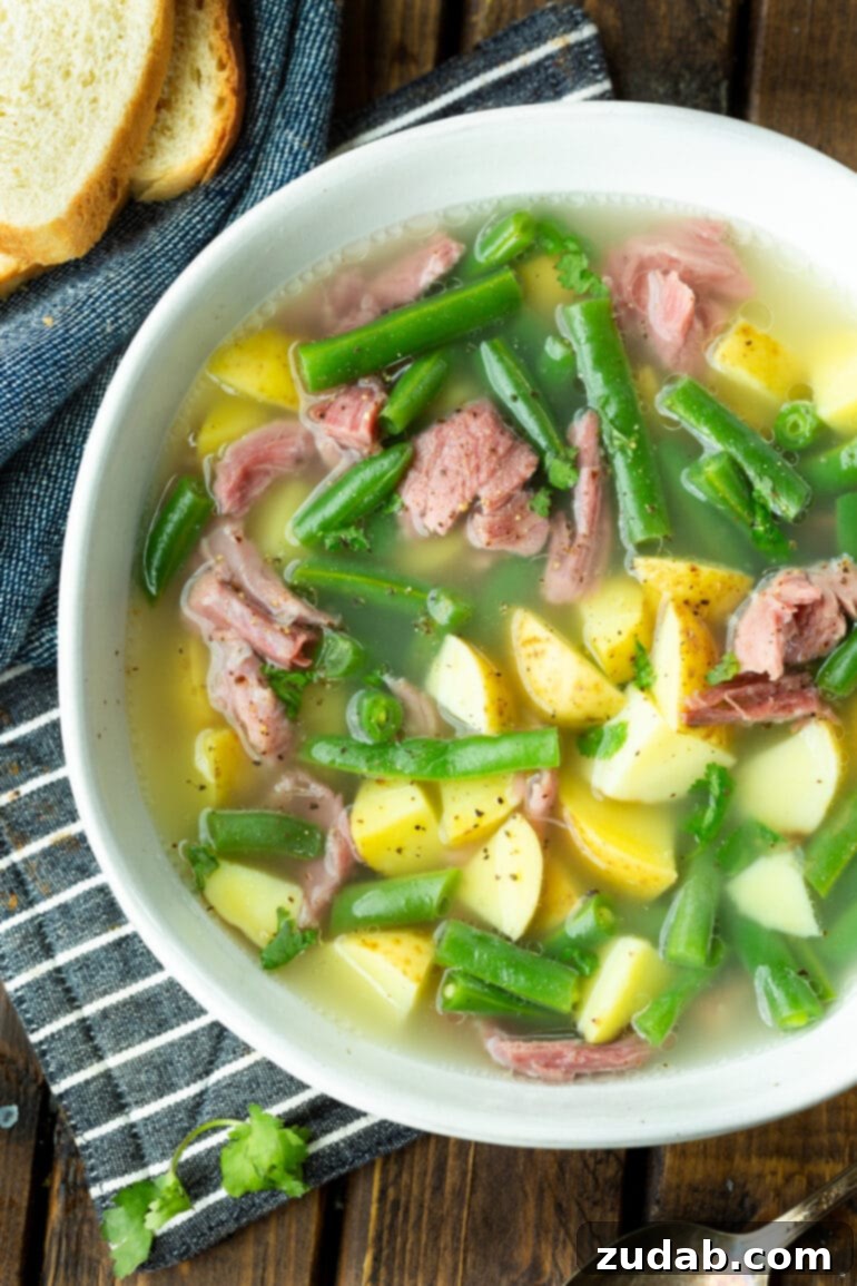 Weekly Menu Plan: April 1-7 4 a photo of a bowl of ham hock soup loaded with potatoes, green beans and chunks of ham