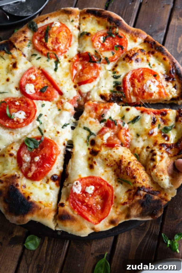 Weekly Menu Plan: April 1-7 7 a photo of a four cheese margherita pizza that has been sliced with two of slices pulled out from the rest of the pizza a little bit.