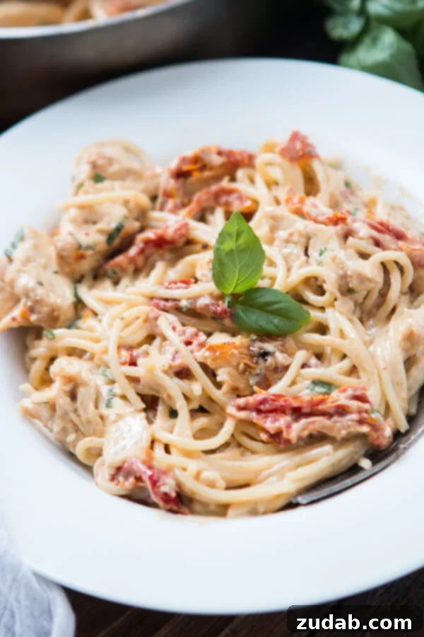 This Week's Menu: April 22-28 4 A close-up shot of a vibrant 20-minute creamy sun-dried tomato chicken pasta dish in a skillet, showcasing the rich sauce, tender chicken, and colorful sun-dried tomatoes.