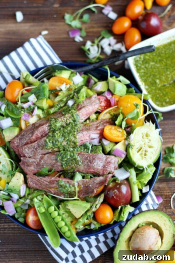 Your Weekly Meal Guide: May 20-26 3 Close-up of a beautifully plated Grilled Flank Steak Salad, featuring tender steak slices, fresh greens, and a vibrant cilantro lime vinaigrette drizzle.
