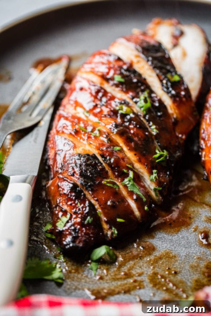 This Week's Meal Plan: May 27 - June 2 3 A beautifully presented grey plate featuring perfectly sliced BBQ chicken, garnished with a sprinkle of fresh parsley, highlighting its juicy tenderness and inviting appeal.