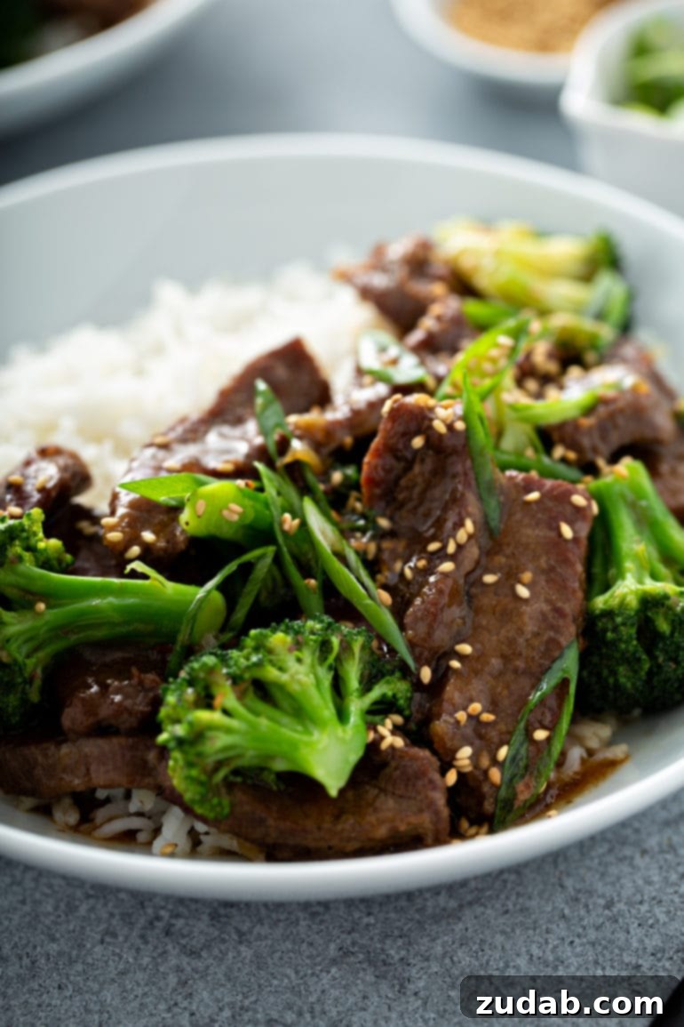 This Week's Meal Plan: May 27 - June 2 6 A close-up photograph showcasing a generous serving of succulent beef and vibrant broccoli, artfully arranged on a pristine plate alongside a bed of fluffy white rice.
