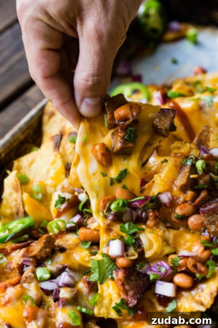 Your Weekly Menu: June 3-9 3 A close-up photo of Ultimate BBQ Brisket Nachos, featuring crispy tortilla chips piled high with shredded brisket, melted cheese, and fresh toppings.