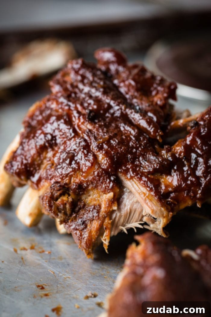 Your Weekly Menu: June 3-9 9 A close-up photo of perfectly grilled BBQ baby back ribs, glistening with barbecue sauce and showing tender, smoky meat.
