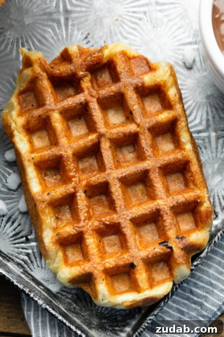 Mastering Waffle Love's Signature Liege Waffles 9 A photo taken over the top of a golden cooked rectangular Liege waffle without any toppings on it yet, highlighting its beautiful texture.