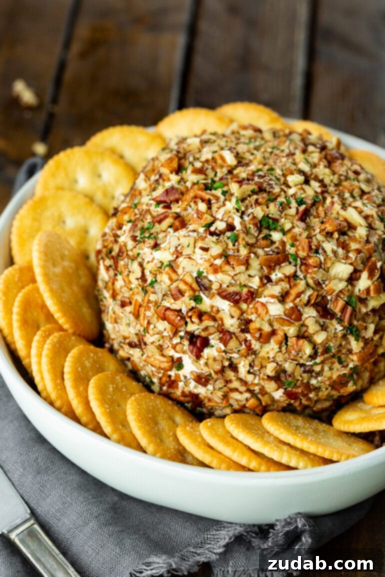 Olympic Celebrations: Red, White, and Blue Recipes 12 a photo of a large cheese ball coated in chopped pecans and minced fresh parsley surrounded by a bunch of Ritz crackers.