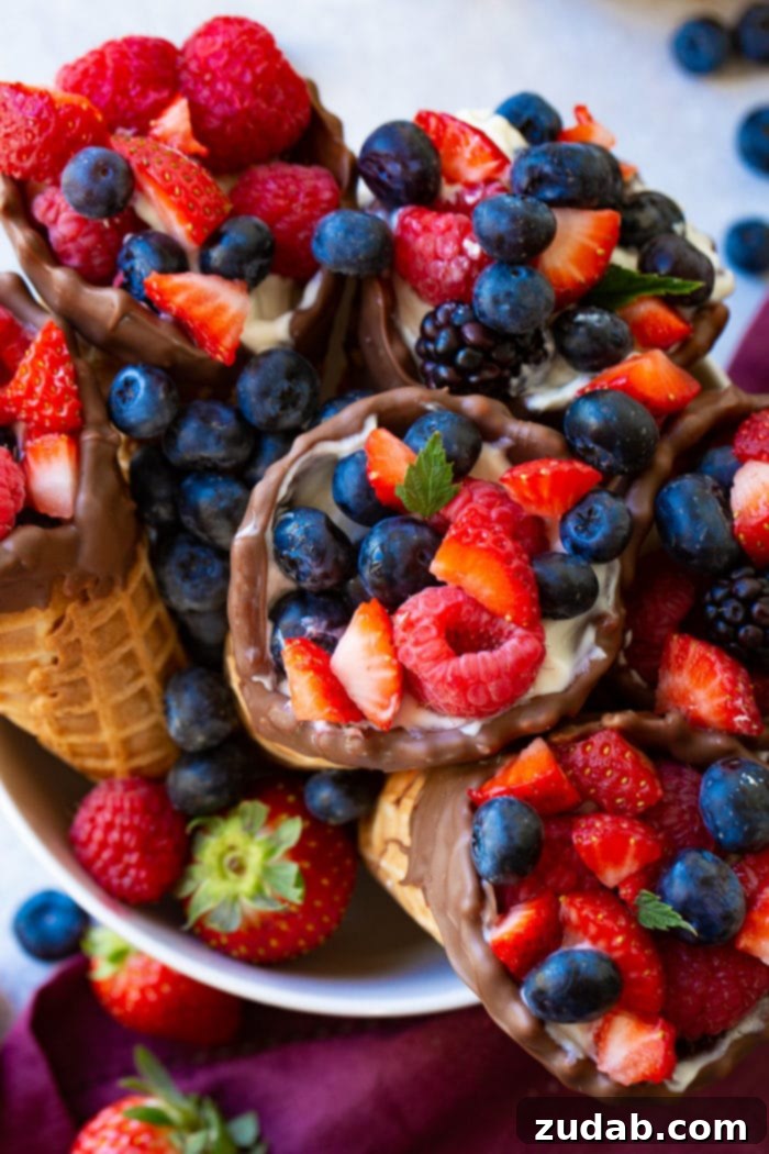Olympic Celebrations: Red, White, and Blue Recipes 5 Overhead shot of waffle cone fruit and yogurt cups in a white bowl with a purple linen underneath.
