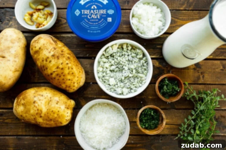 Decadent Blue Cheese Potato Gratin 4 All the fresh ingredients for making blue cheese potato gratin, including large russet potatoes, crumbled blue cheese, fresh thyme, garlic cloves, olive oil, and salt and pepper, artfully arranged on a kitchen surface.