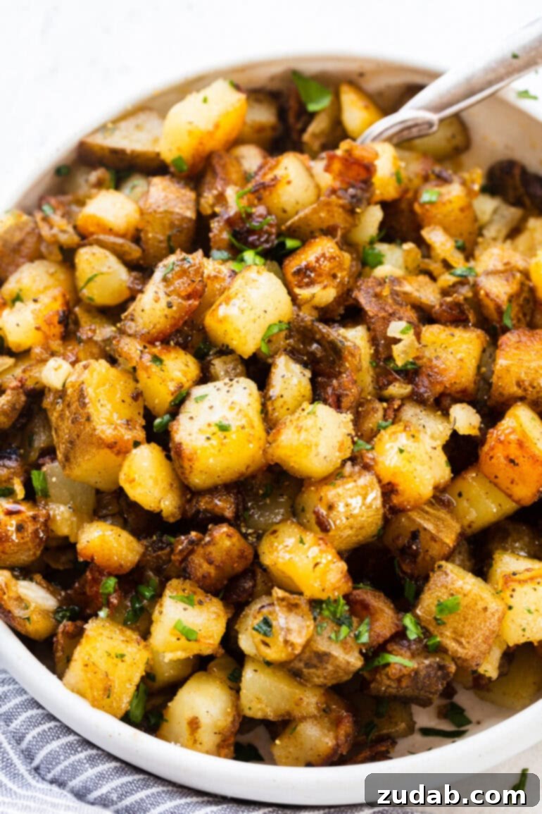 Ultimate Home Fries Recipe 3 A top-down photo of a large white serving bowl brimming with golden, crispy, cubed potatoes, ready to be enjoyed as a perfect side dish.