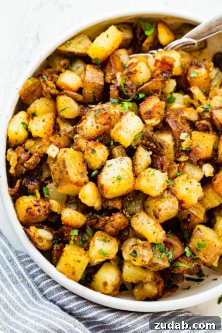 Ultimate Home Fries Recipe 4 A photo of a large serving bowl filled with golden, crispy cubed potatoes, lightly seasoned and ready to be served.