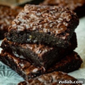 A perfectly baked square of homemade fudgy brownie with a rich, dark color and crinkle top, seen from above.