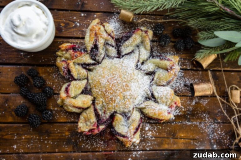 Blackberry Snowflake Puff Pastry 7 A delectable blackberry puff pastry snowflake, exquisitely dusted with powdered sugar, sitting on a charming wooden table, ready to be enjoyed.