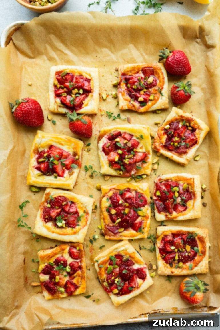 Effortlessly Gourmet Roasted Strawberry Blue Cheese Tarts 5 A display of several golden-baked roasted strawberry and blue cheese tarts, ready to be enjoyed as a gourmet appetizer.