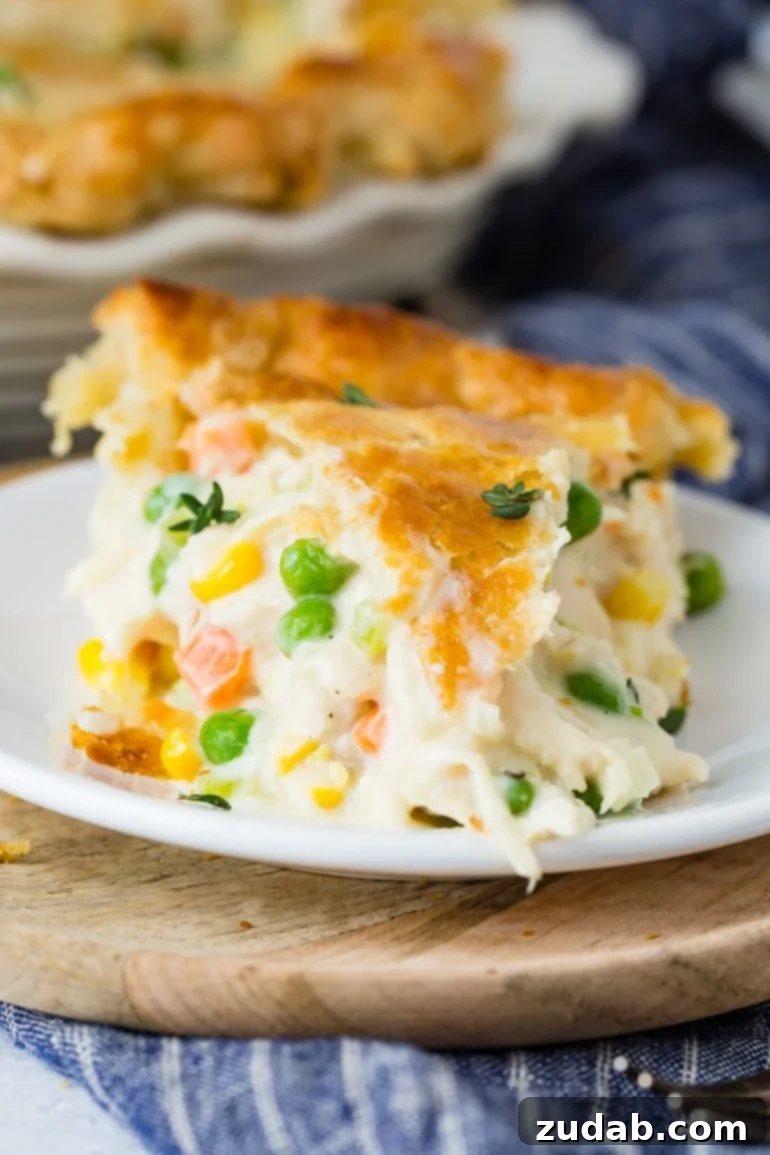 This Week's Meal Plan: September 23-29 6 A close-up, tempting view of a generous slice of golden-crusted Chicken Pot Pie, revealing its rich and creamy interior packed with succulent chicken pieces, bright carrots, and green peas.