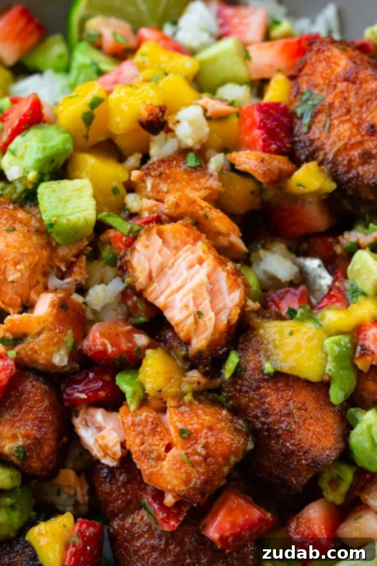 Golden Crispy 7-Minute Air Fryer Salmon Bites with Zesty Mango Salsa 3 A close-up photograph showcasing crispy air fryer salmon bites generously mixed with a vibrant strawberry mango avocado salsa, highlighting the freshness and texture of the dish.