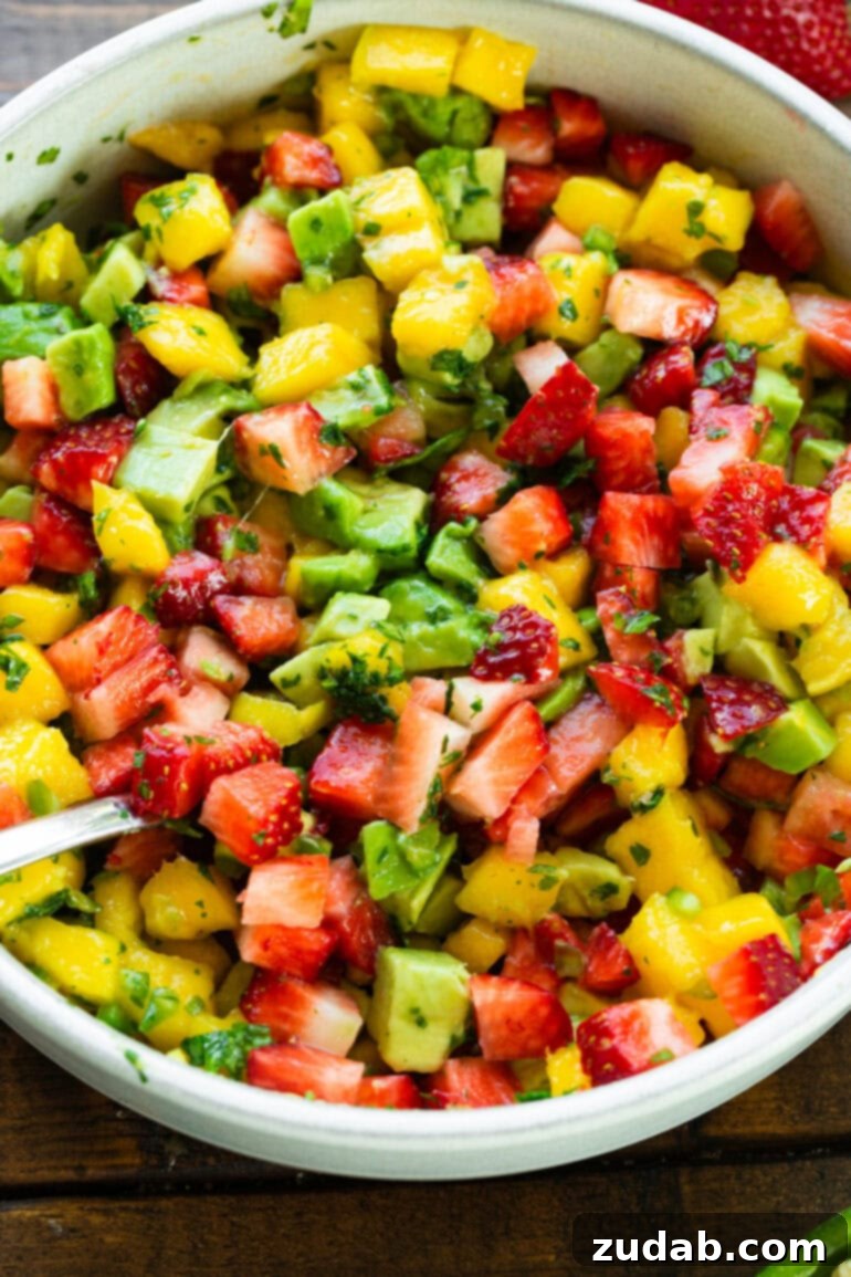 Golden Crispy 7-Minute Air Fryer Salmon Bites with Zesty Mango Salsa 7 A vibrant and colorful bowl of freshly prepared strawberry avocado mango salsa, meticulously tossed with chopped cilantro and finely minced jalapeños, ready to serve.