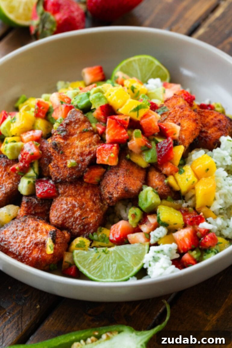 Golden Crispy 7-Minute Air Fryer Salmon Bites with Zesty Mango Salsa 10 A vibrant bowl of coconut rice generously topped with crispy air fryer salmon bites and a fresh avocado mango salsa, showcasing a healthy and flavorful meal.