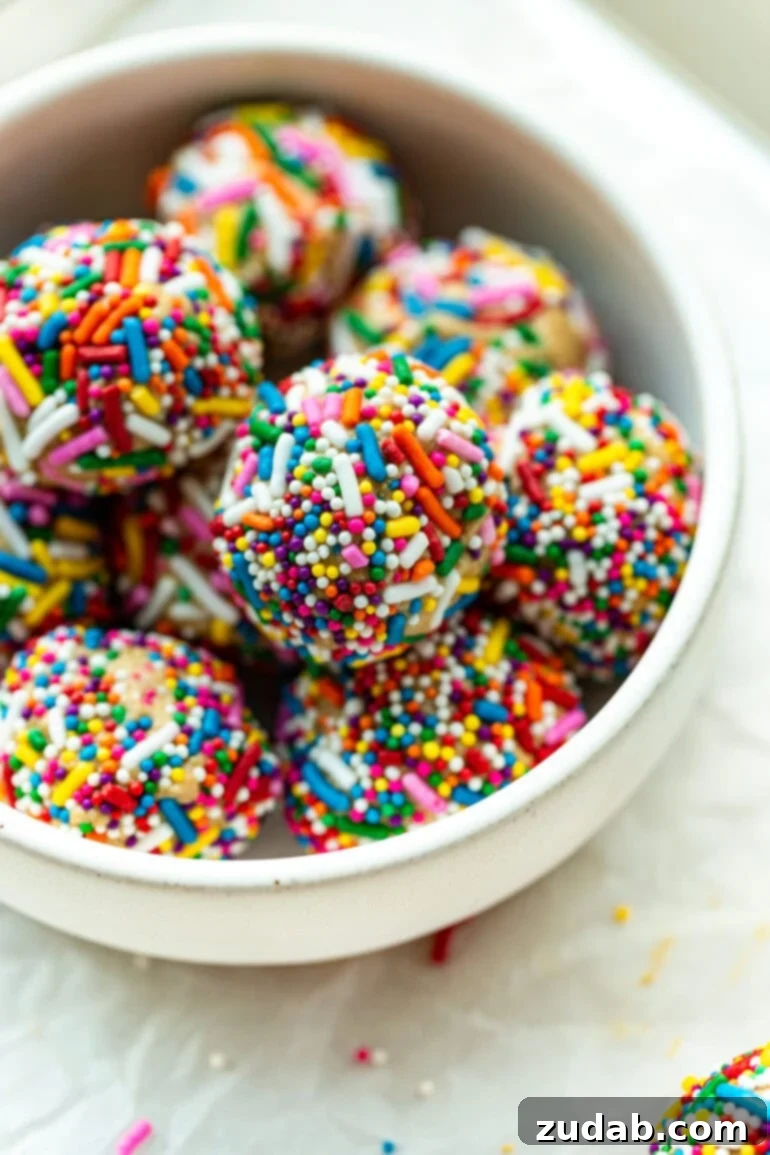 Funfetti Protein Poppers 6 a photo of several protein balls coated in rainbow sprinkles sitting in a white bowl