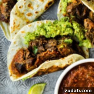 Deliciously Easy 5-Ingredient Shredded Beef Tacos 16 a photo of a shredded beef taco on a flour tortilla and topped with guacamole
