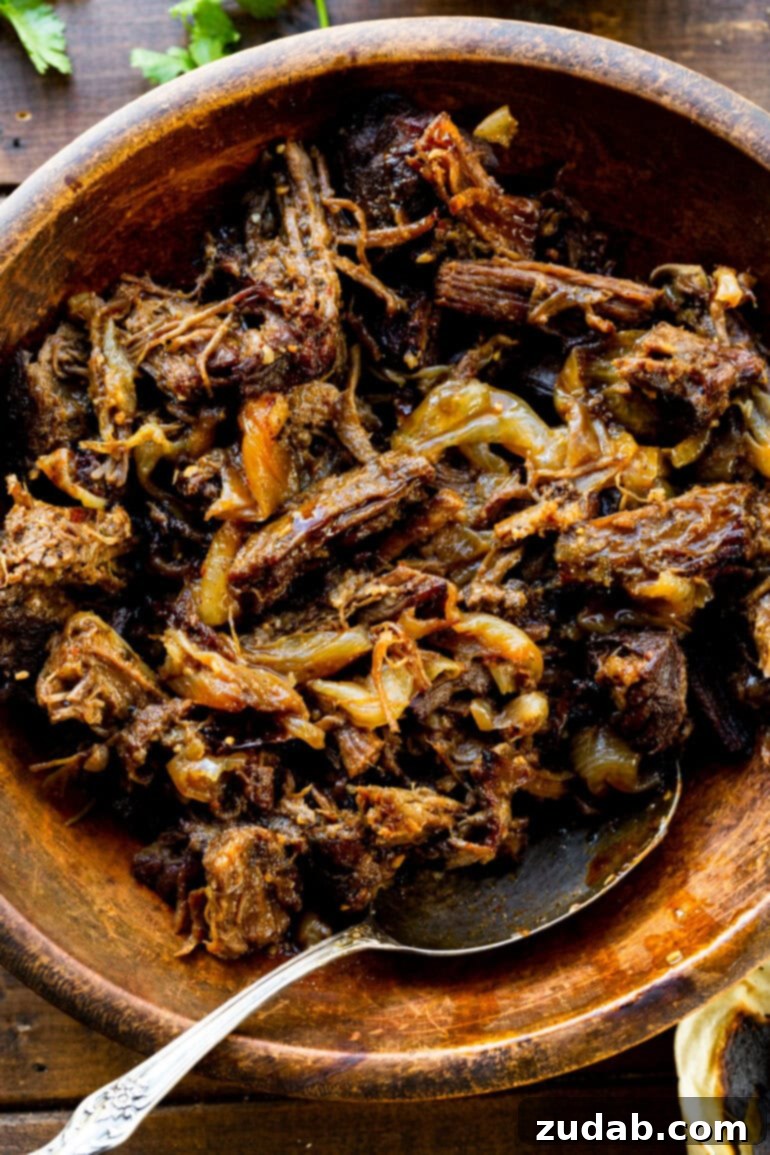 Deliciously Easy 5-Ingredient Shredded Beef Tacos 4 A rustic wooden serving bowl brimming with tender, juicy shredded beef, seasoned to perfection and ready to be enjoyed.