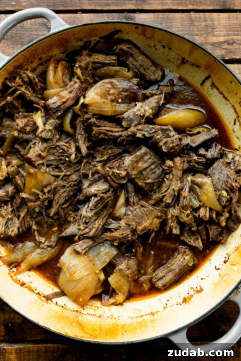 Deliciously Easy 5-Ingredient Shredded Beef Tacos 6 A close-up of tender, flavorful shredded beef, freshly pulled from the oven, glistening with juices.