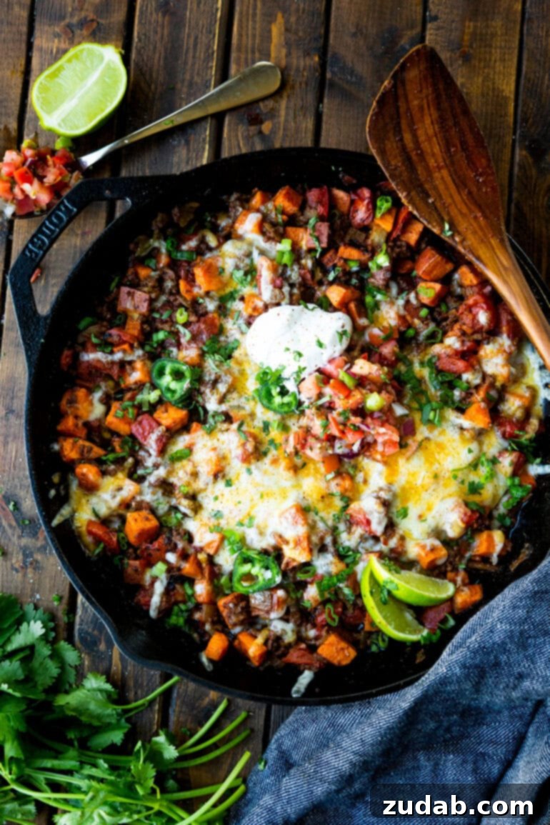 Taco Beef and Sweet Potato Skillet 5 A top-down view of a cast iron skillet filled with a rich and savory mixture of cubed sweet potatoes and taco-seasoned ground beef, ready for the final toppings. This image captures the hearty essence of this easy one-pan meal, perfect for a quick and satisfying dinner.
