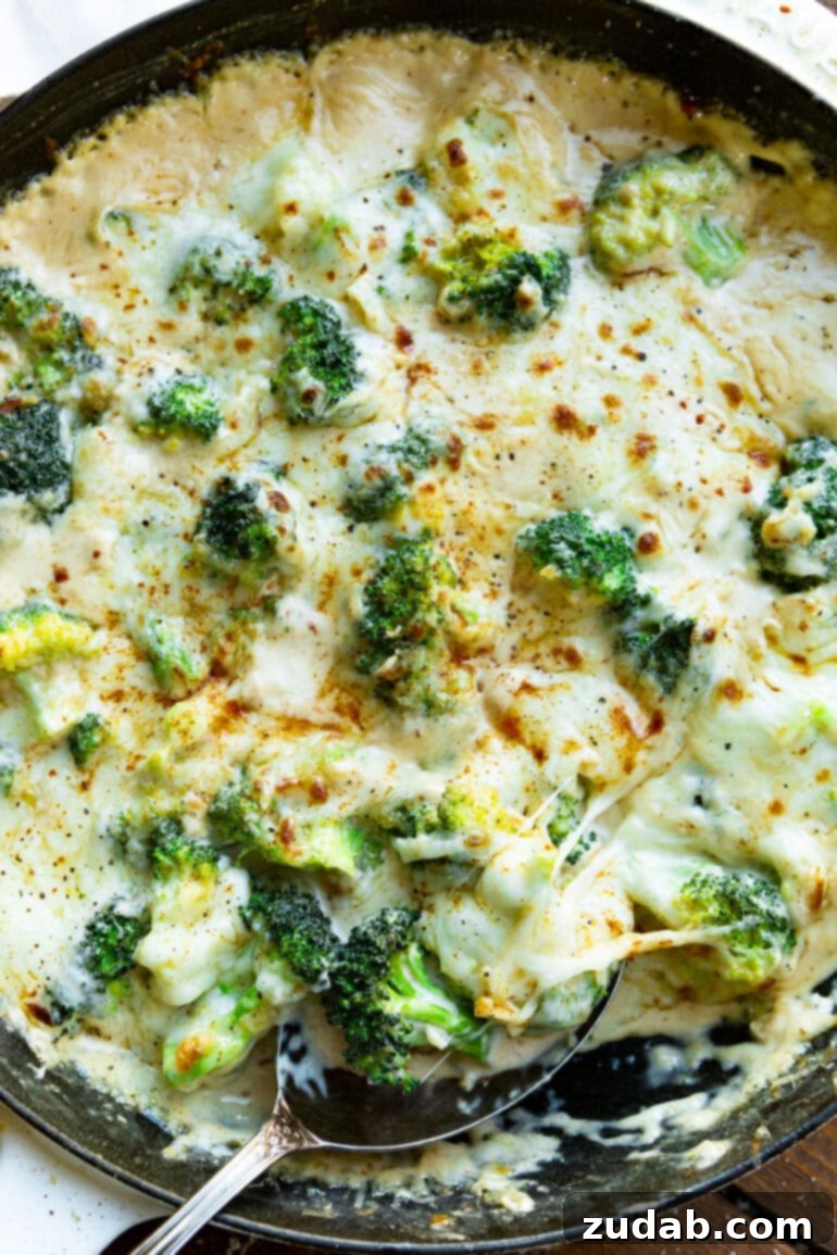 Parmesan Garlic Velvet Broccoli 7 Close-up of creamy Parmesan garlic broccoli sprinkled with vibrant Aleppo pepper, showing its rich texture and color.