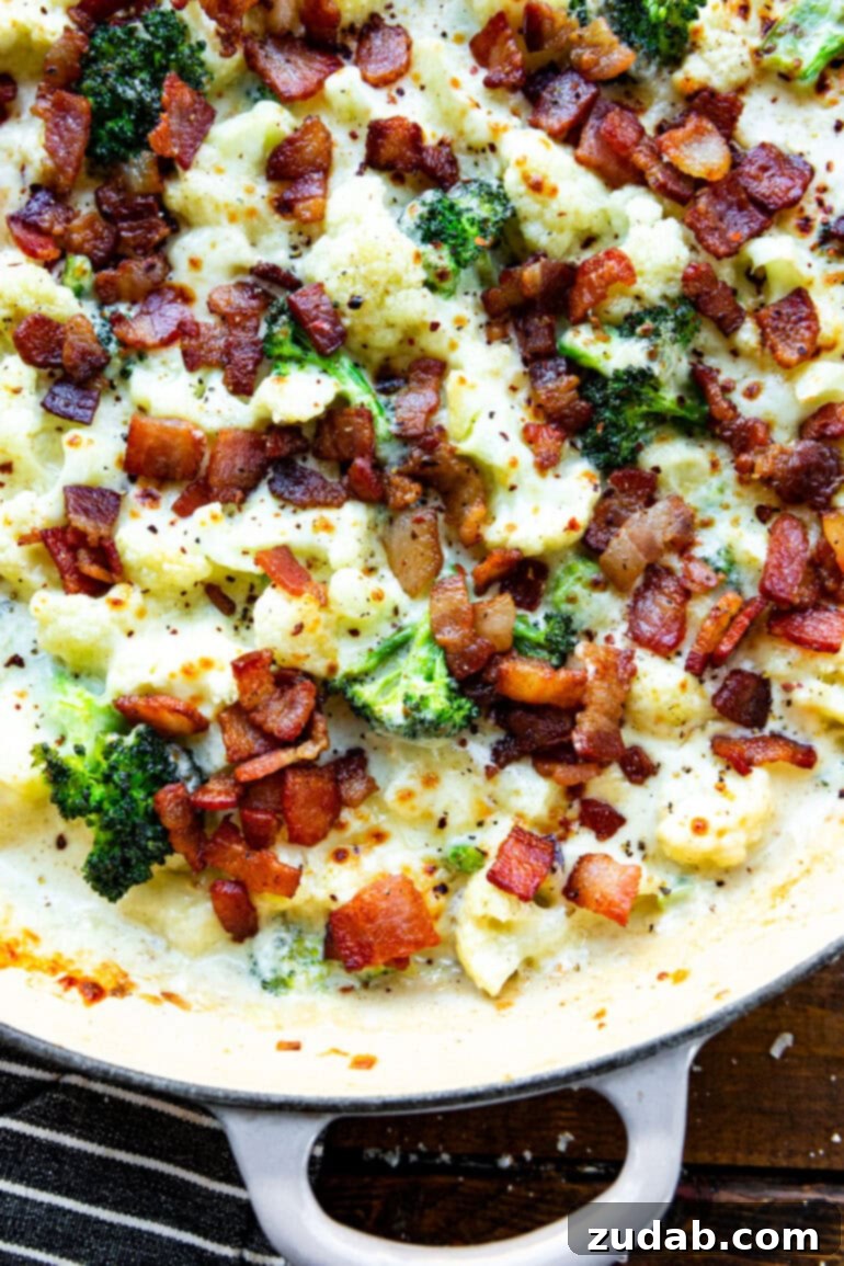 Creamy Garlic Parmesan Broccoli Cauliflower with Crispy Bacon 4 A mouthwatering overhead shot of a large cast-iron skillet filled with creamy garlic parmesan broccoli and cauliflower, freshly removed from the oven, with the cheese bubbling and golden, and generously topped with crispy bacon.
