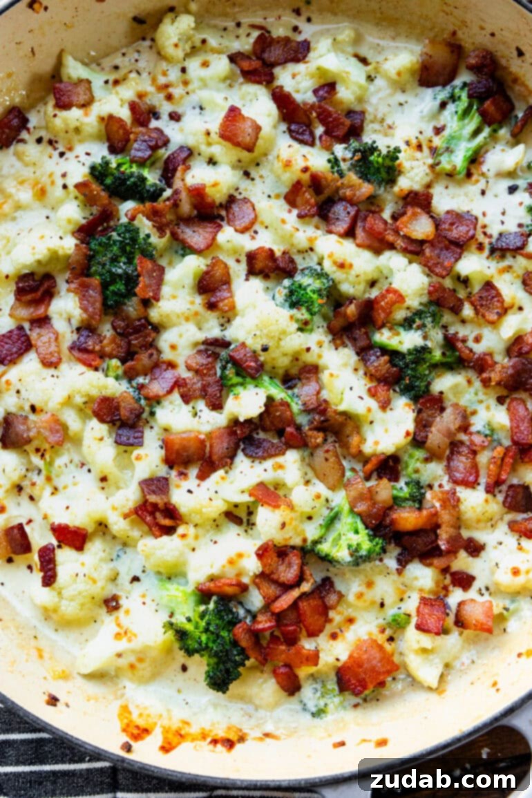 Creamy Garlic Parmesan Broccoli Cauliflower with Crispy Bacon 9 A beautifully composed photo of a skillet overflowing with creamy garlic parmesan cauliflower and broccoli, garnished with fresh herbs, hinting at the rich and delicious flavors within.