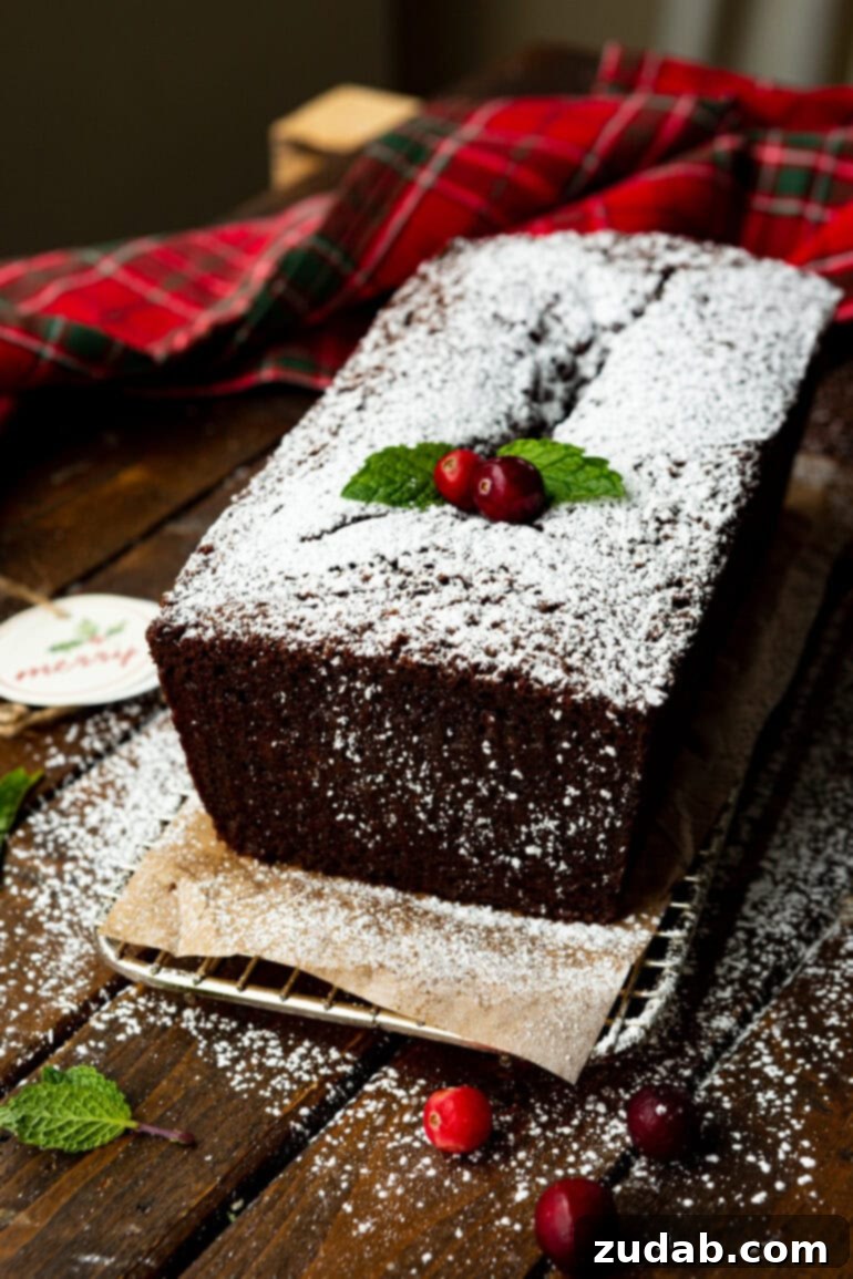 Warm Spiced Gingerbread Loaf 12 A whole gingerbread loaf dusted with powdered sugar and adorned with whole cranberries and mint leaves.