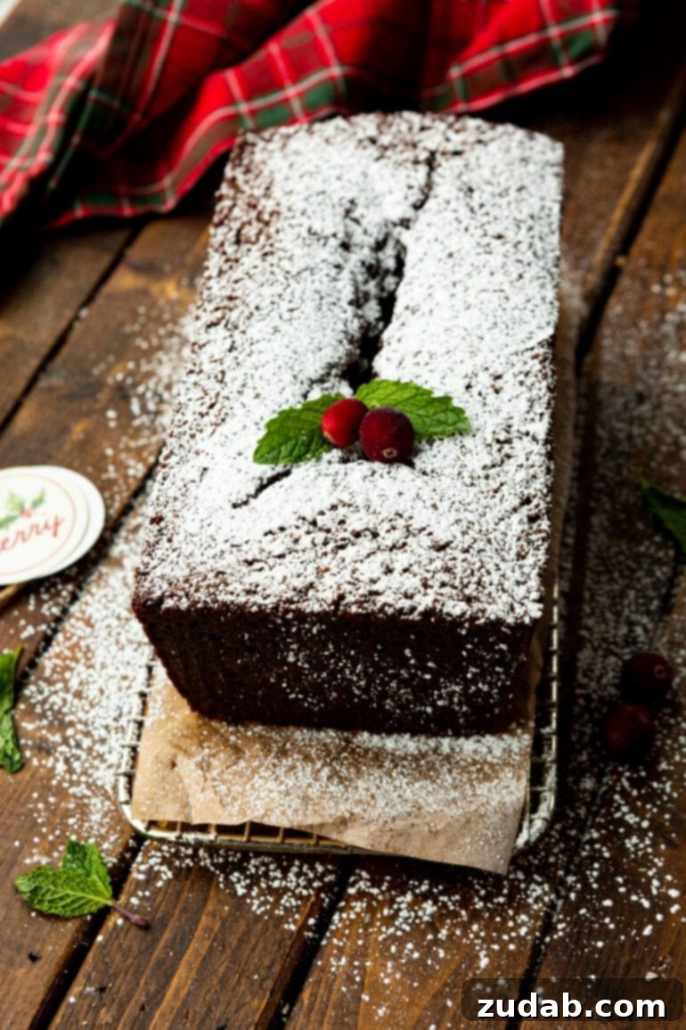 Warm Spiced Gingerbread Loaf 10 A full gingerbread loaf, dusted with powdered sugar and garnished with whole cranberries and evergreen sprigs.